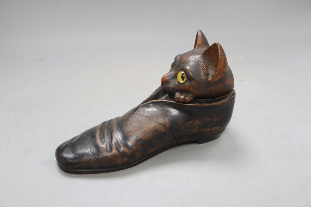 An early 20th century carved wood cat in a shoe inkwell, with hidden compartments, length 20cm